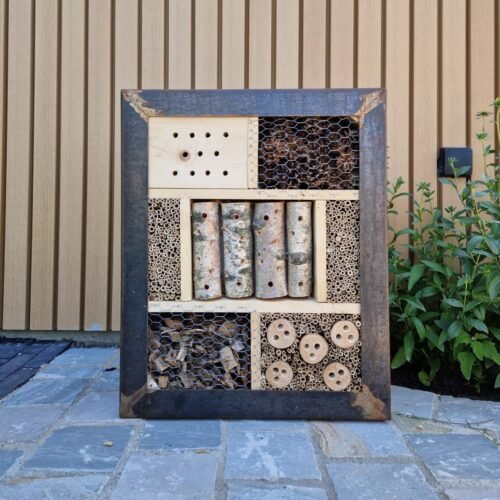Handgemaakt insectenhotel van cortenstaal in de tuin